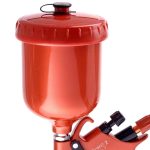 Red air blow gun with attached pressure tank and ergonomic handle for industrial use.