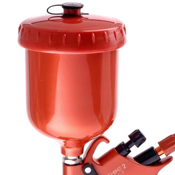 Red air blow gun with attached pressure tank and ergonomic handle for industrial use.